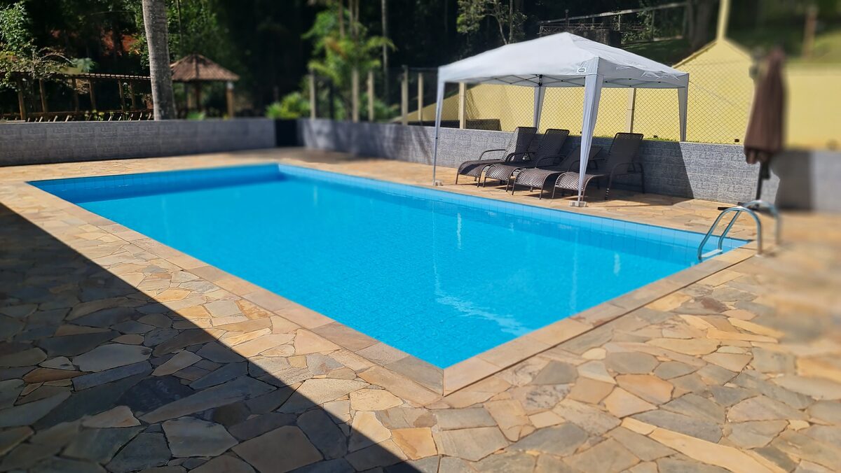 Piscina ao ar livre com deck de pedra